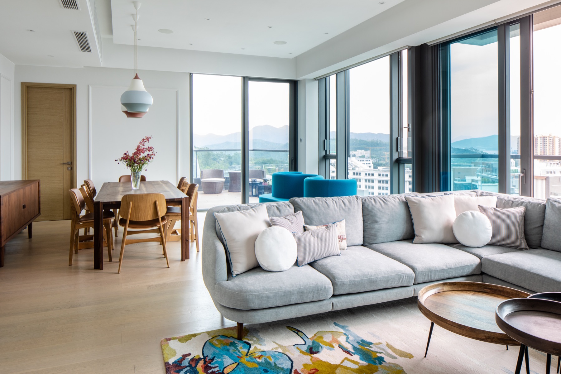 Bright contemporary living room with panoramic windows and blue accents
