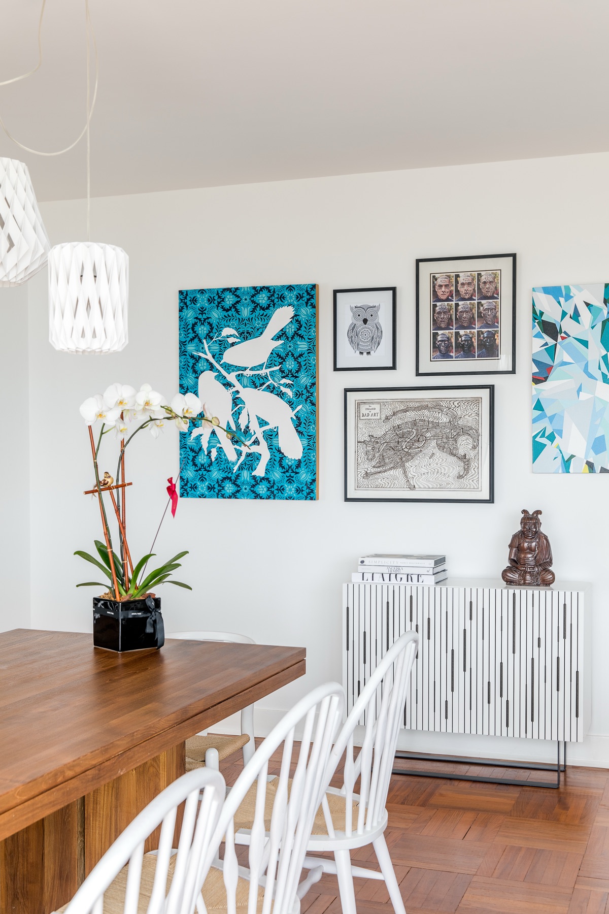 Eclectic interior with turquoise artwork and a geometric white console