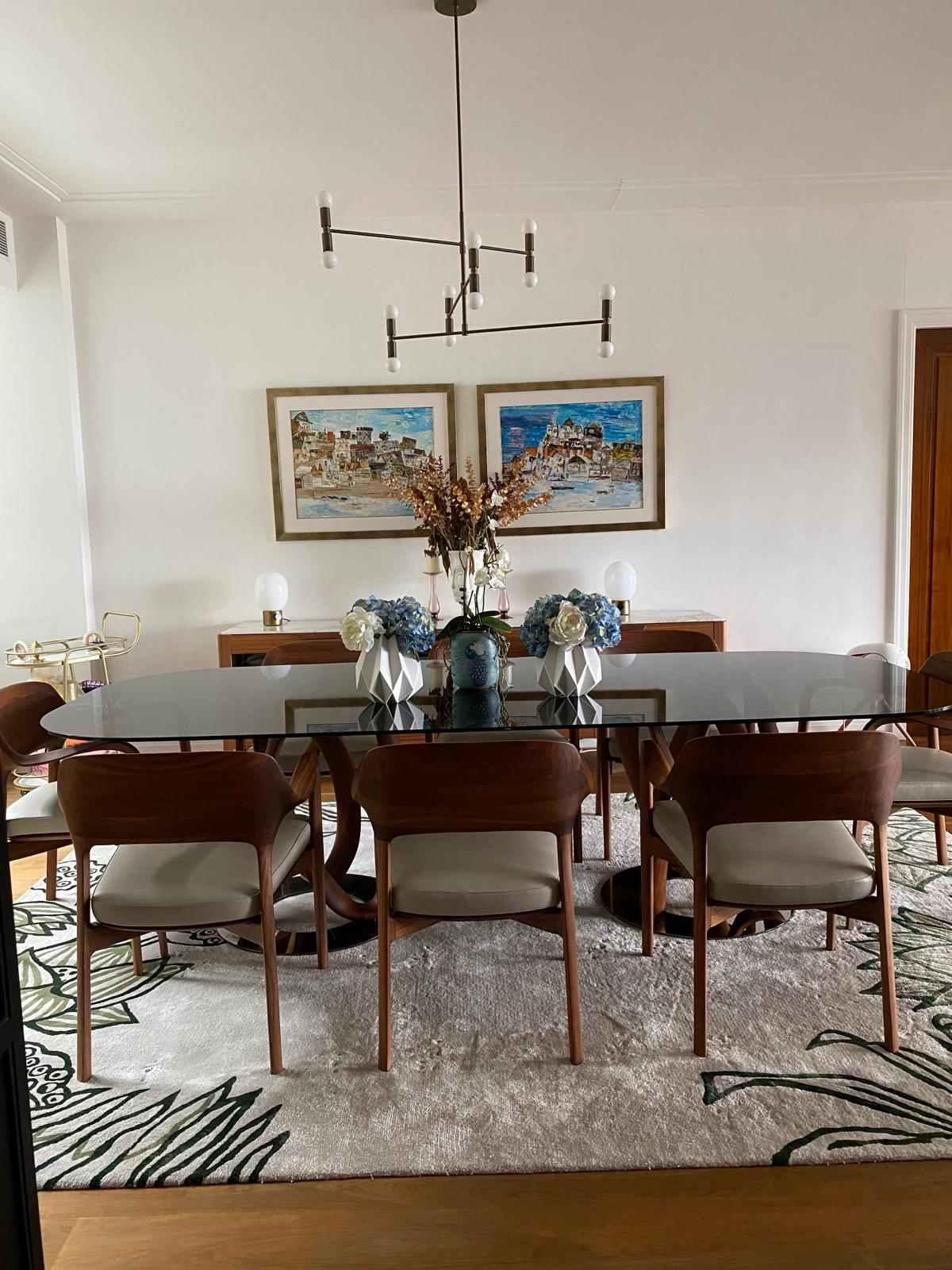 Timber dining table with cream upholstered chairs beneath a black linear pendant