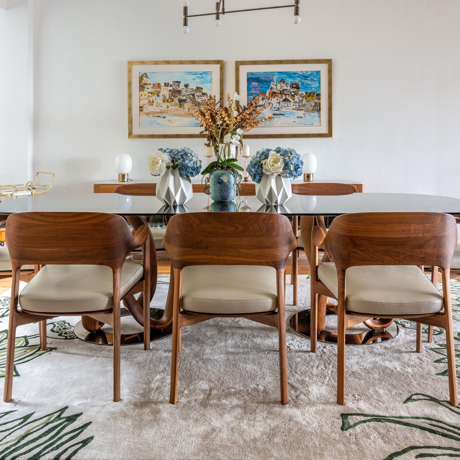 Cream dining chairs at a timber table beneath paired framed artworks