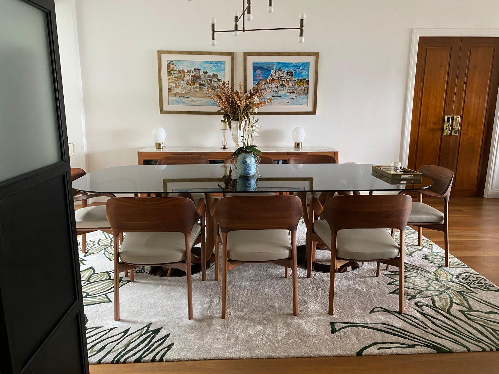 Dining table and cream chairs viewed through a doorway beneath a black pendant
