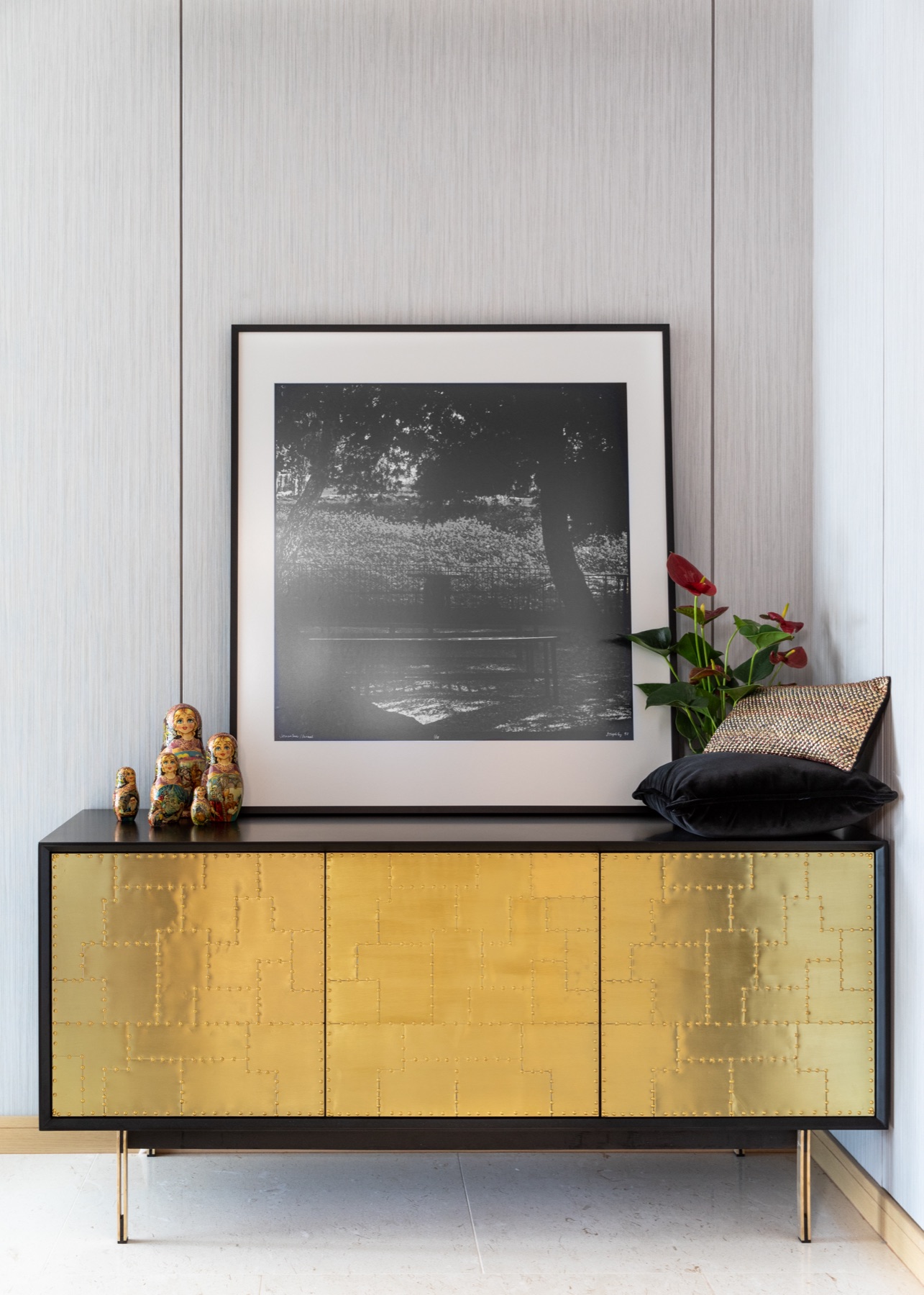 Sculptural brass cabinet with monochrome artwork and collected objects